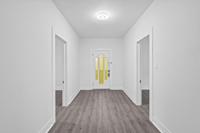 hallway with baseboards and wood finished floors