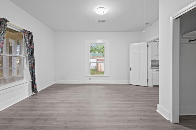 interior space featuring baseboards, visible vents, and wood finished floors