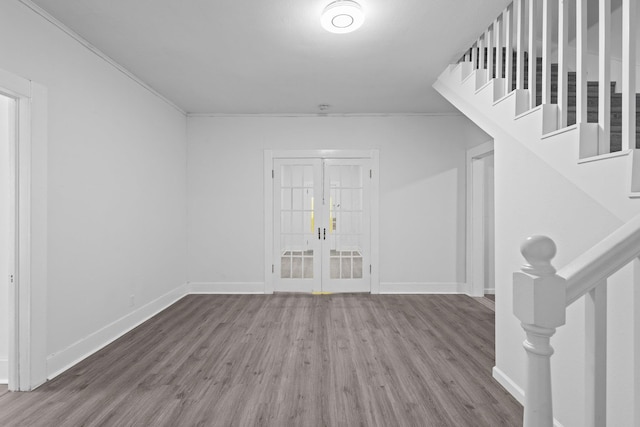 interior space featuring crown molding, wood finished floors, baseboards, stairway, and french doors