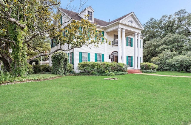 greek revival inspired property featuring a front lawn