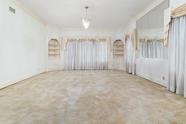 spare room featuring carpet flooring, built in features, and crown molding