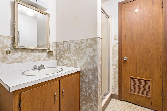 bathroom featuring vanity and a shower with shower door