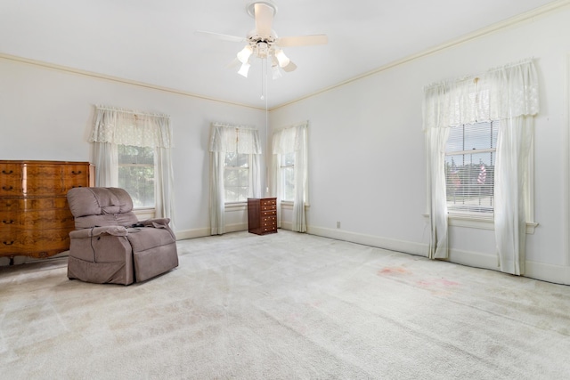 sitting room with light carpet, crown molding, ceiling fan, and a healthy amount of sunlight