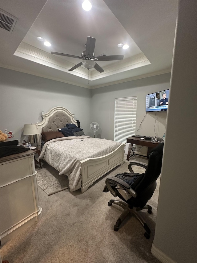 carpeted bedroom featuring a tray ceiling, ceiling fan, and ornamental molding