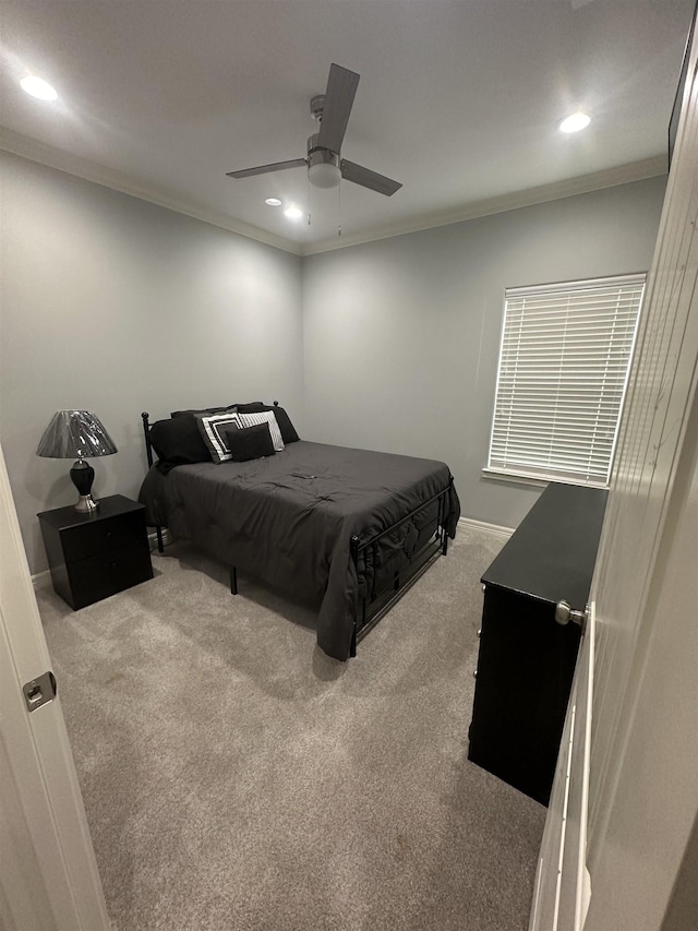 bedroom with ceiling fan, light colored carpet, and crown molding