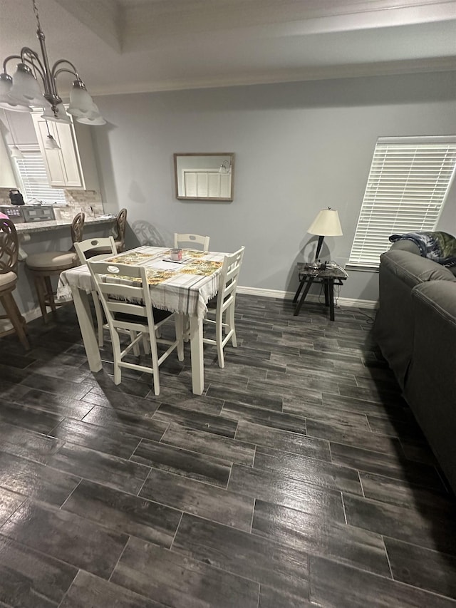 dining area with crown molding and a chandelier