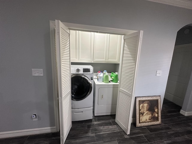 clothes washing area with washer and clothes dryer and cabinets