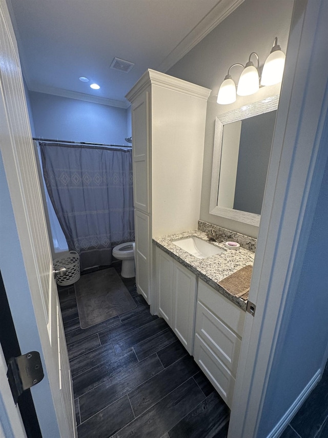 bathroom with a shower with shower curtain, vanity, toilet, and ornamental molding