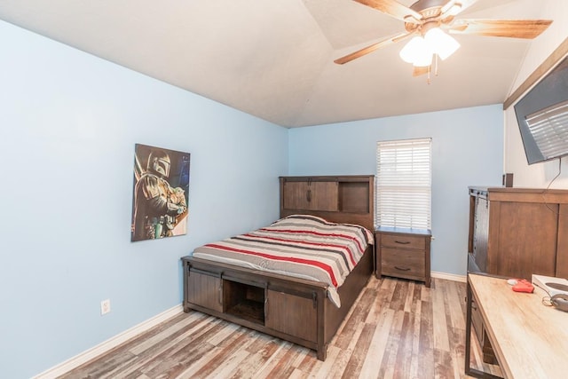 bedroom featuring ceiling fan, light wood-type flooring, and vaulted ceiling