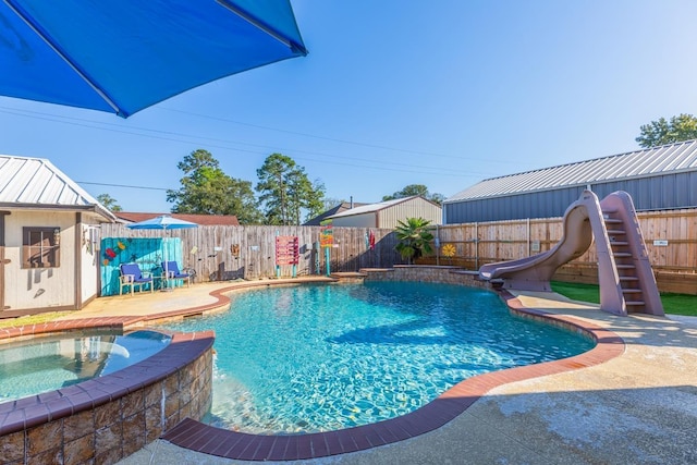 view of swimming pool with a patio area, an in ground hot tub, and a water slide