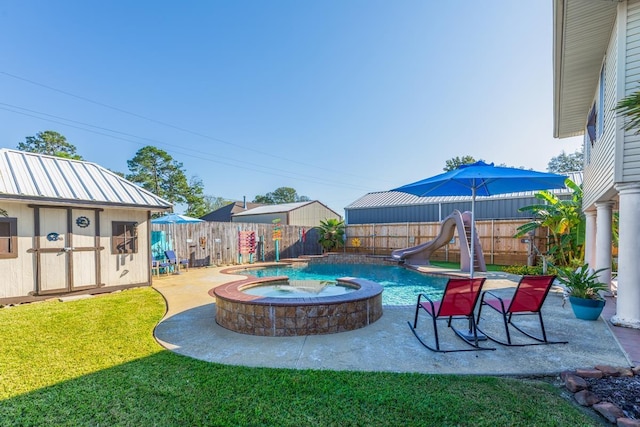 view of pool with a lawn, a shed, an in ground hot tub, and a water slide