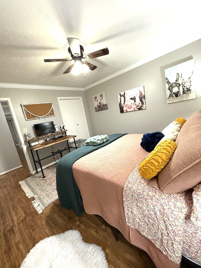 bedroom with a textured ceiling, ornamental molding, a ceiling fan, and wood finished floors