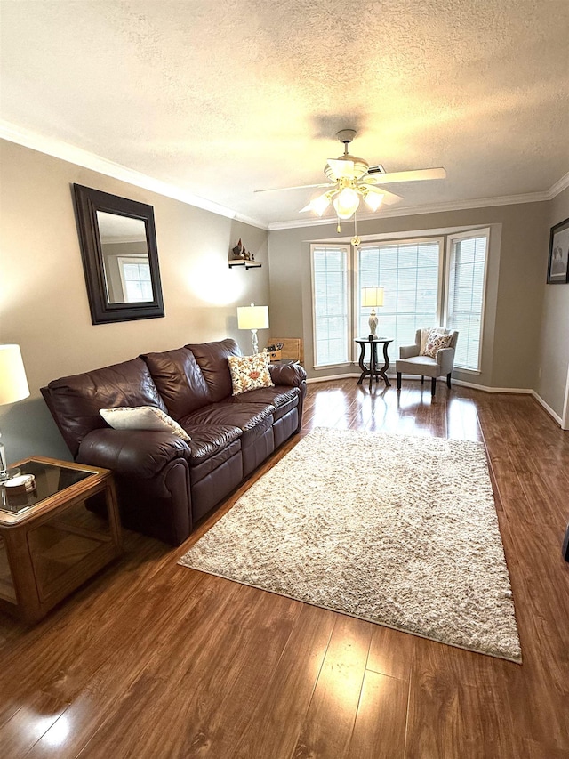 living area featuring ceiling fan, a textured ceiling, crown molding, wood finished floors, and baseboards