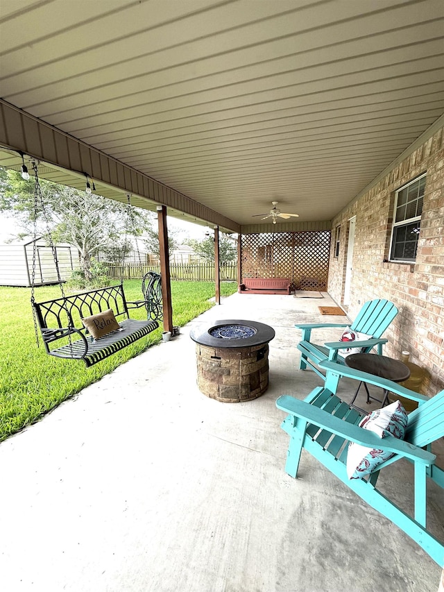 view of patio / terrace with fence, ceiling fan, and an outdoor fire pit