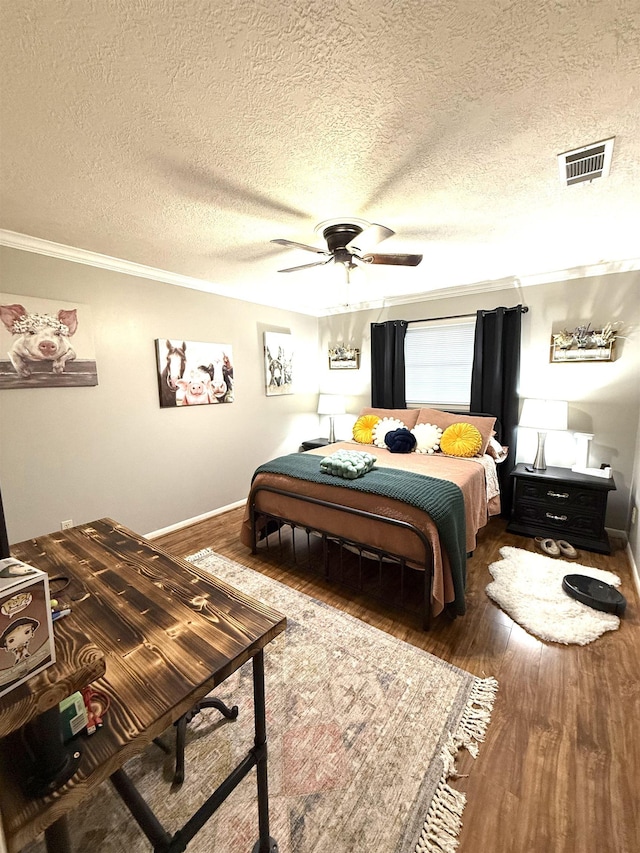 bedroom featuring visible vents, ornamental molding, and wood finished floors