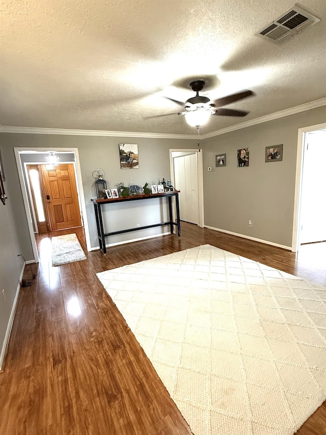 foyer featuring visible vents, a ceiling fan, baseboards, and dark wood-type flooring