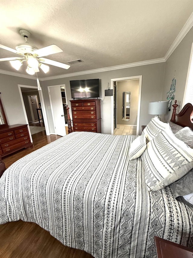 bedroom featuring crown molding, ceiling fan, wood finished floors, and visible vents