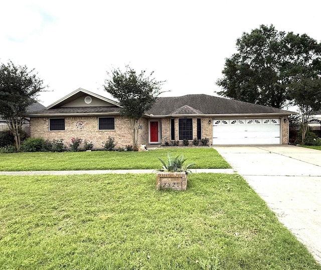 ranch-style house with an attached garage, driveway, brick siding, and a front yard