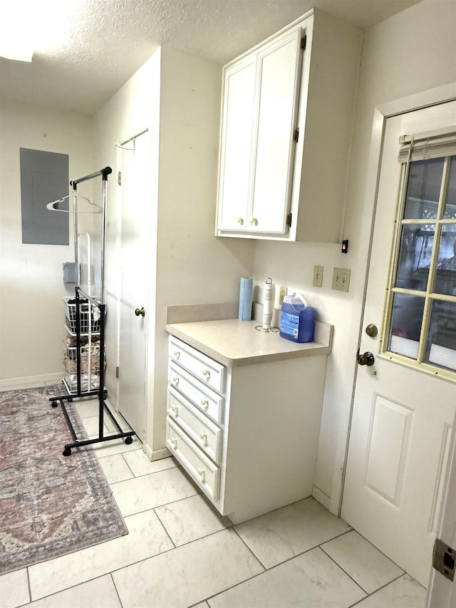 laundry room with a textured ceiling and electric panel