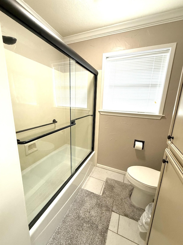 full bath with tile patterned flooring, ornamental molding, toilet, and bath / shower combo with glass door