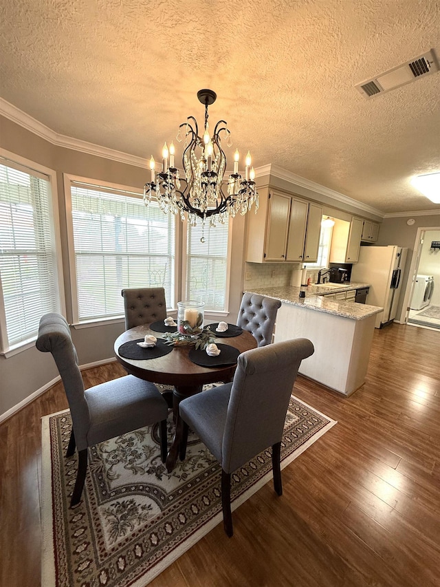 dining area with crown molding, visible vents, a textured ceiling, dark wood finished floors, and a notable chandelier