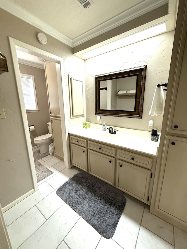 bathroom with vanity, ornamental molding, and toilet