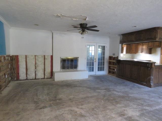 unfurnished living room featuring ceiling fan, a textured ceiling, and french doors