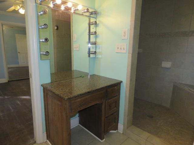 bathroom featuring tile patterned floors, ornamental molding, vanity, ceiling fan, and tiled shower