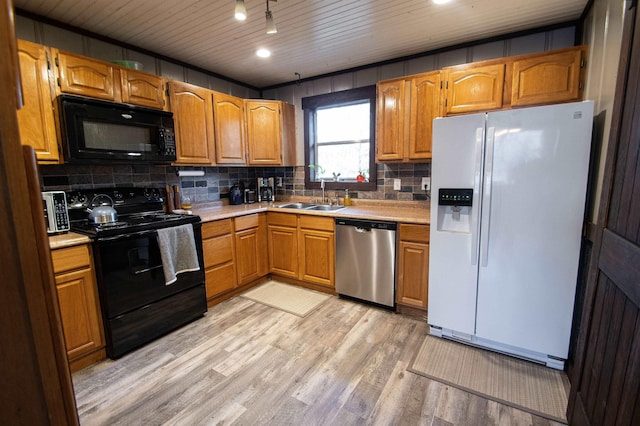 kitchen with sink, decorative backsplash, light hardwood / wood-style floors, and black appliances