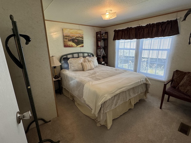 carpeted bedroom featuring ornamental molding and a textured ceiling