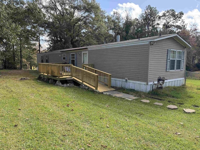 rear view of house with a wooden deck and a lawn