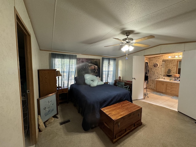 bedroom featuring lofted ceiling, ceiling fan, light carpet, and a textured ceiling