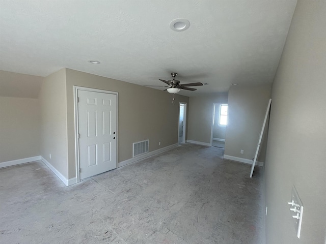 interior space featuring baseboards, a textured ceiling, visible vents, and a ceiling fan