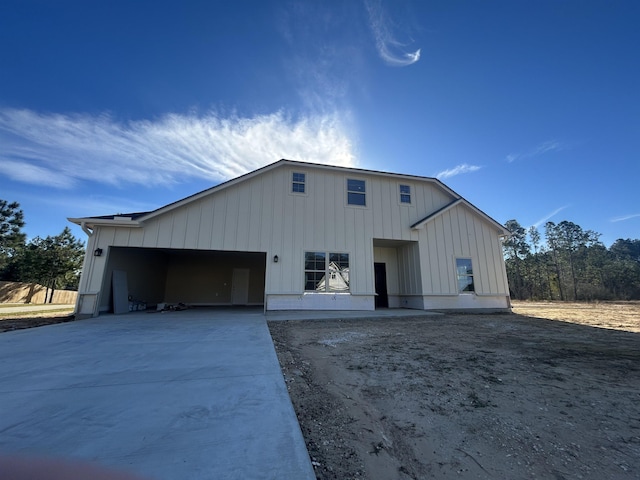 view of front of property with concrete driveway, board and batten siding, and an attached garage