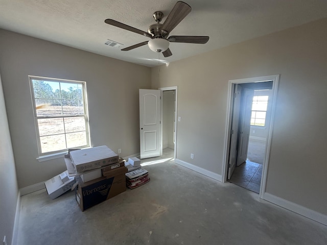 unfurnished bedroom featuring visible vents, a ceiling fan, connected bathroom, unfinished concrete floors, and baseboards