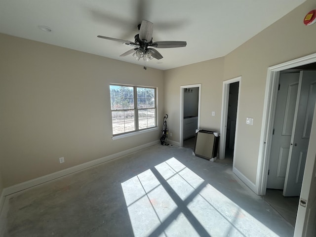 unfurnished bedroom featuring ceiling fan, concrete floors, and baseboards