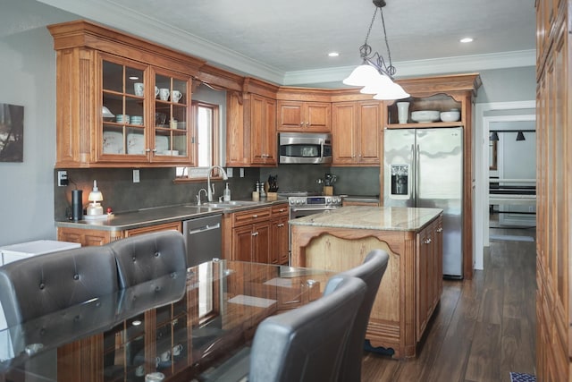 5200 N Fm 105, Vidor, TX 77662 - kitchen with stainless steel appliances, a sink, brown cabinets, a center island, and crown molding