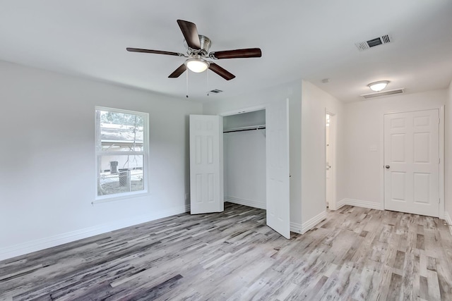 unfurnished bedroom featuring ceiling fan, light hardwood / wood-style floors, and a closet