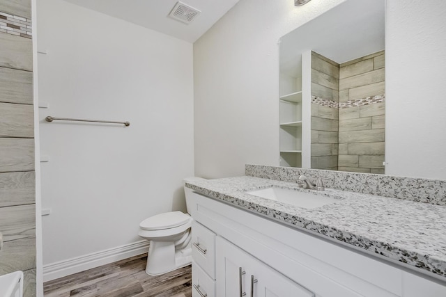 bathroom with toilet, vanity, and hardwood / wood-style flooring