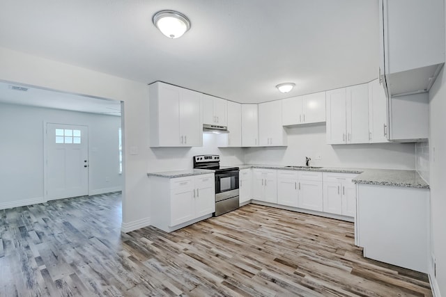 kitchen with stainless steel range with electric cooktop, white cabinets, sink, light hardwood / wood-style flooring, and light stone countertops