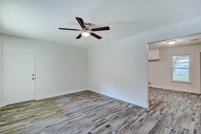 unfurnished room with light wood-type flooring and ceiling fan