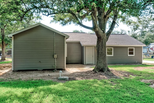 rear view of property featuring a lawn