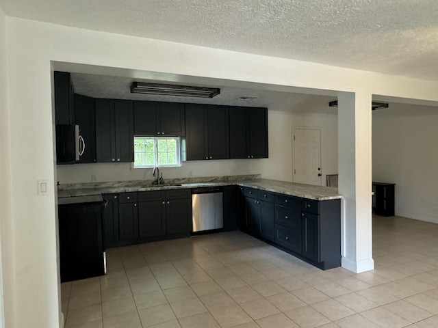 kitchen with light stone counters, light tile patterned floors, sink, and appliances with stainless steel finishes