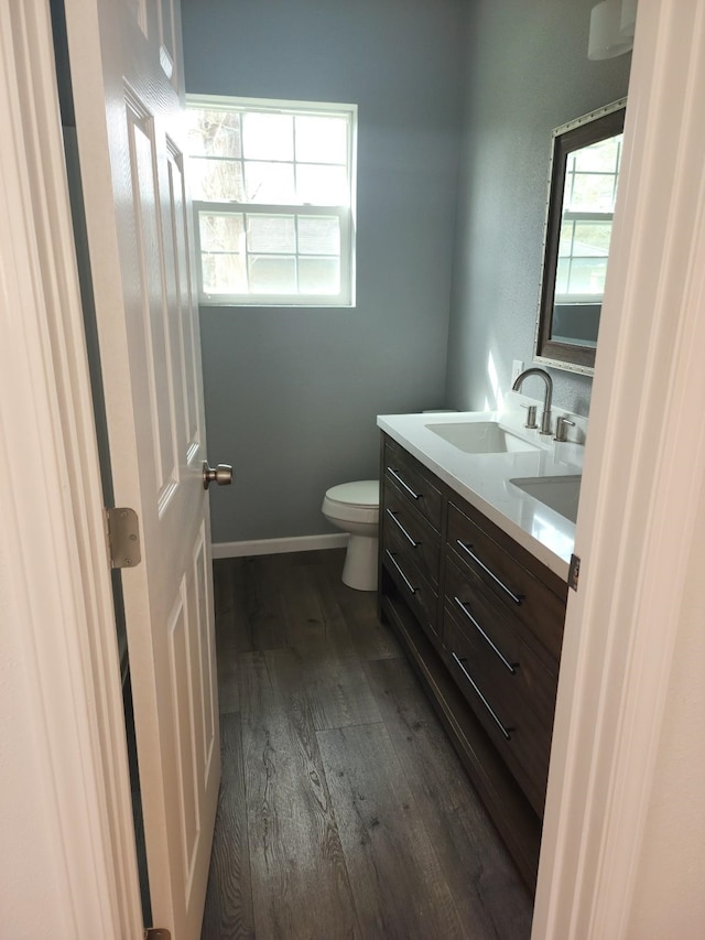 bathroom featuring wood-type flooring, vanity, and toilet