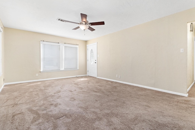 carpeted spare room with ceiling fan