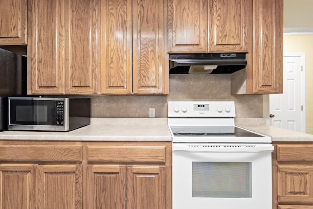 kitchen with white electric stove and decorative backsplash