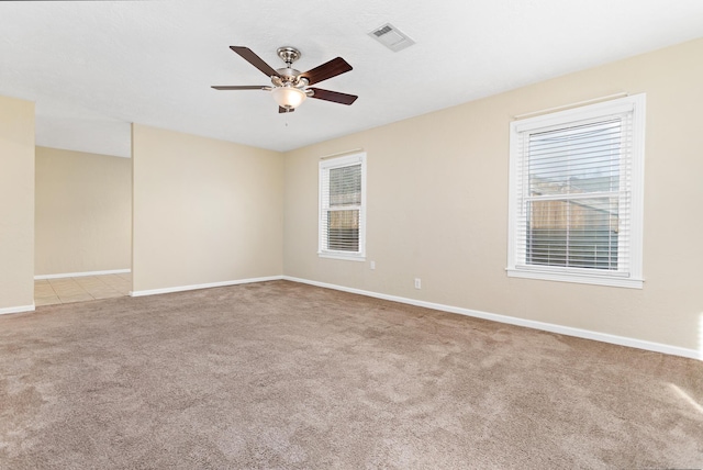 carpeted spare room featuring ceiling fan