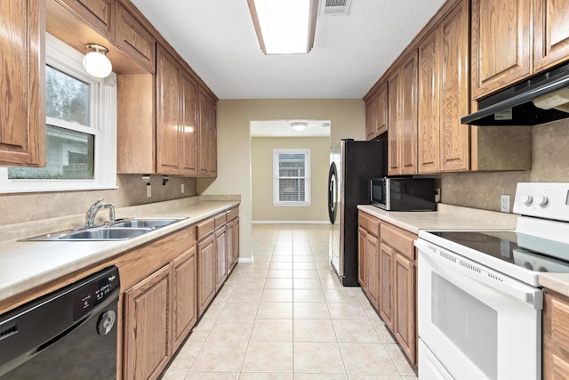 kitchen featuring sink, plenty of natural light, stainless steel appliances, and light tile patterned flooring