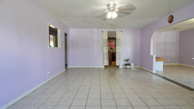 tiled spare room featuring ceiling fan