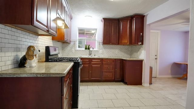 kitchen with sink, stainless steel range with gas cooktop, light stone counters, decorative backsplash, and light tile patterned floors